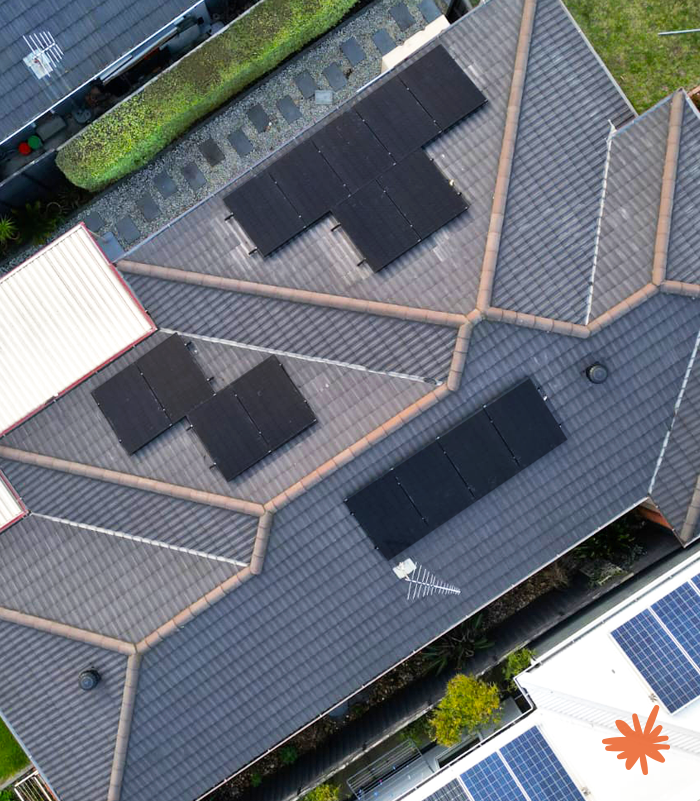 Aerial view of a Queensland home with multiple Weglow rooftop solar panel arrays installed on tiled roof sections for residential clean energy generation.